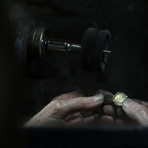 A jeweller smoothens a gold medal at his workshop in central Madrid