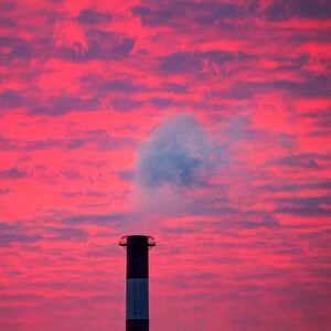 Steam rises from a smoke stack at sunset in Lansing, Michigan