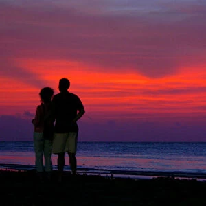 Tourists enjoy the sunset at Kovalam beach