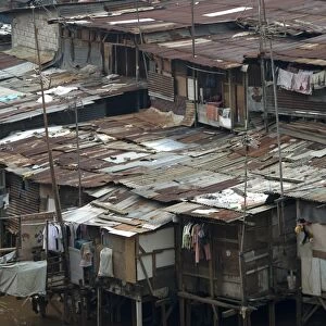 Stilted shacks with corrugated iron roofs beside river in city, Manggarai District, Jakarta, Java, Indonesia, December