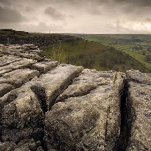 View of limestone pavement in upland landscape at sunset, above Malham Cove, Malhamdale, Yorkshire Dales N. P