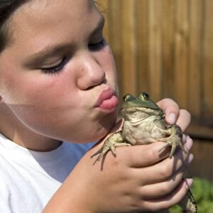 11 year old girl kissing a bullfrog in Boise, Idaho. (MR)