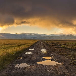 USA, Wyoming, Grand Tetons. Sunrise over mountains and road in landscape. Credit as