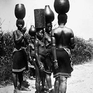 AFRICA: ZULU WOMEN. Zulu women and children balancing water jugs on their heads, Africa