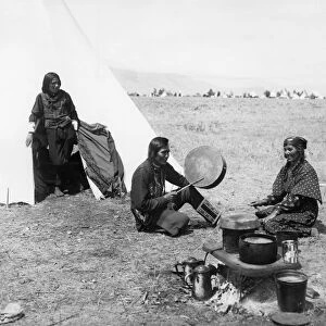 FLATHEAD COUPLE, c1905. Mose Vandenburg, a Flathead Native American, playing a