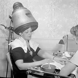 NEW YORK: BEAUTY, 1942. Woman getting a manicure while her hair dries at the salon
