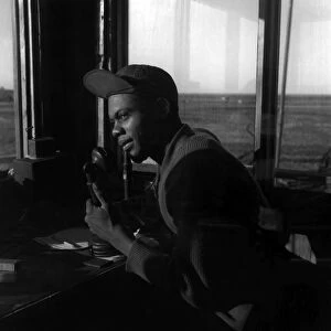 TUSKEGEE AIRMAN, 1945. Sergeant William Bostic of the Tuskegee Airmen 301st Fighting Squad, in the control tower at Ramitelli Airfield, Italy. Photograph by Toni Frissell, March 1945