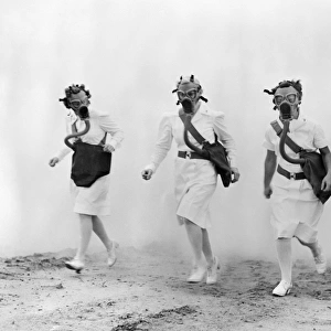 WORLD WAR II: NURSES. U. S. Army nurses advance through a cloud of smoke in a gas mask drill during training at Scott Field, Illinois. Photograph, c1942