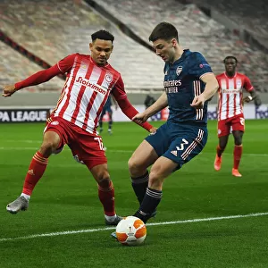 Arsenal's Kieran Tierney Clashes with Olympiacos Kenny Lala in Empty Europa League Stadium