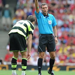 Referee Andre marriner shows a yellow card to Charlie Mulgrew (Celtic)