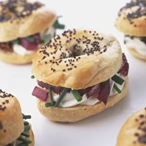 Baby bagels filled with roasted red onion, goats cheese and chives, close up