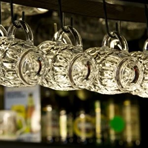 Beer glasses hanging on hooks in traditional pub