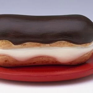 Chocolate eclair made out of plastic on a red plate
