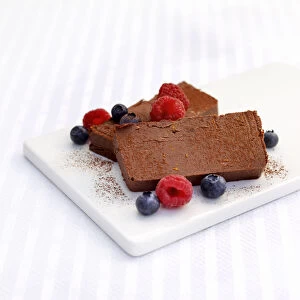 Chocolate parfait with blueberries and raspberries on chopping board