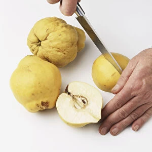 Chopping quinces with a sharp knife, close-up