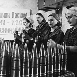 Civilian women making artillery shells at a munitions factory in moscow during world war 2, the sign behind them reads: defenders of moscow! the soviet people are with you