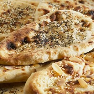 Close-up of naan breads with a variety of toppings