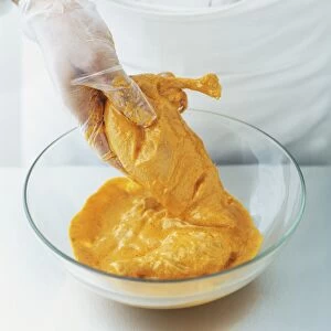 Coating chicken in curry marinade