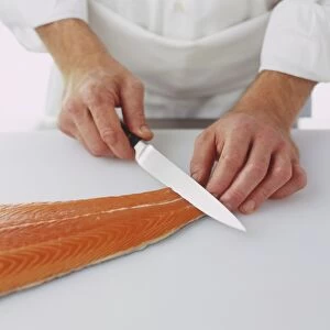 Cutting into tail end of a salmon fillet