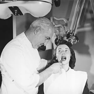 Dentist pulling womans tooth