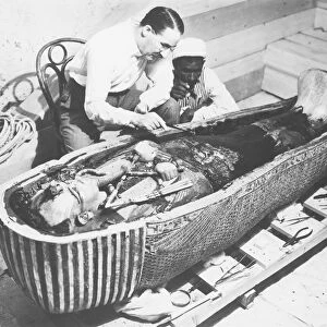 Egypt, Valley of the Kings, The discovery of the tomb of Pharaoh Tutankhamun (or Tutankhamen, circa 1340-1323 B. C. archaeologist Howard Carter (1874-1939) examining the third mummy-shaped sarcophagus, 1922, vintage photograph