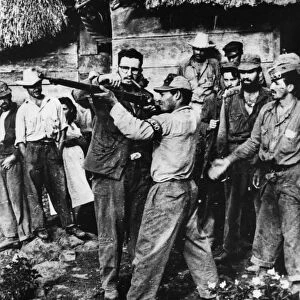 Fidel castro giving rifle instruction to new recruits to his revolutionary army in sierra maestra, a guerrilla base in cuba, late 1950s