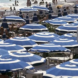 France, Nice, Promenade des Anglais, busy beach with bright blue umbrellas