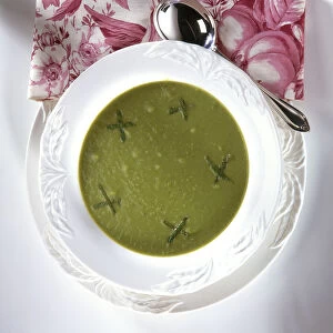 French Pea Soup served in white bowl, garnished with fresh mint