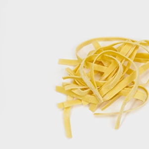 Fresh egg tagliatelle pasta on white background