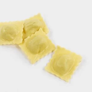 Fresh ravioli pasta against white background