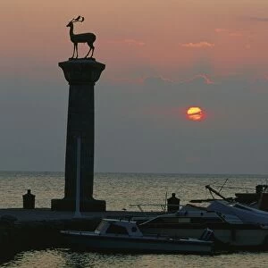Greece, Rhodes, deer statues of Elafos and Elafina stand atop columns above boats moored in Mandraki harbour