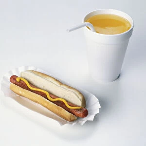 A hotdog, and a soft drink in paper cup with drinking straw