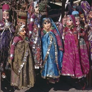 India, Sireh Deori Bazaar, brightly coloured puppets for sale, wearing brightly coloured traditional Indian dress, female puppets wearing vivid saris, male puppets with large black moustache, hanging by red string