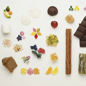 Large selection of cake decorations, including marzipan fruit and flowers, hundreds and thousands, chocolate flake, marshmellow and chocolate bar