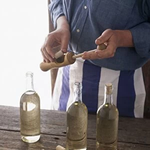 Man corking bottles of home-made wine