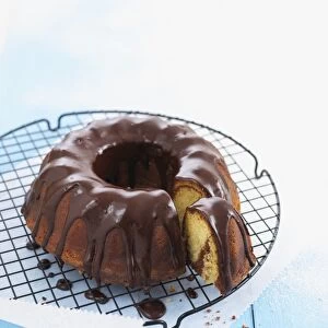 Marble cake with chocolate icing on cooling rack, single slice cut away