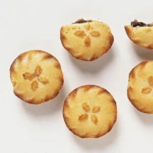 Five mince pies, two of them partly-eaten, close up