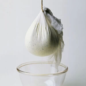 Muslin bag containing yoghurt based soft cheese (labna), suspended above bowl
