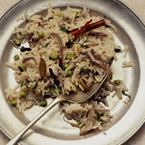 Mutter pulao served on metal plate with spoon, close up