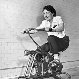 An older woman pedals on her exercycle