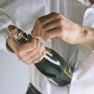 Person opening champagne bottle