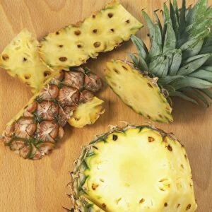 Pineapple skin being cut off the fruit, view from above