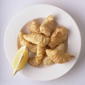 Plate of Filetti di baccala, deep-fried fillets of cod and slice of lemon, a traditional dish from Rome, Italy, view from above