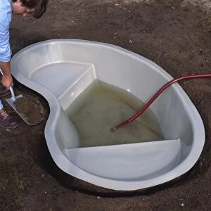 Pond mould being filled up with water through a hose pipe