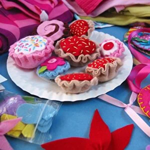 Pretend picnic with colourful cakes made from fabric at the centre, close-up