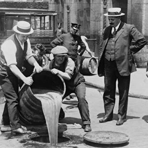 Prohibition in the USA 1920-1933: A barrel of confiscated illegal beer being poured down a drain