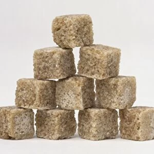 Raw brown sugar cubes stacked in a stepped pyramid