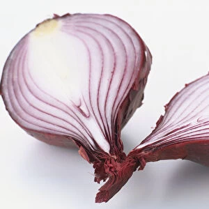 Red onion sliced in half, showing cross section and distinctive papery red skin