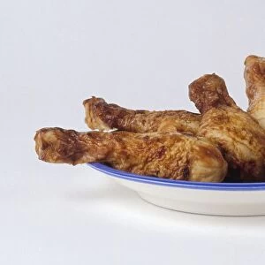 Five roast chicken legs on blue plate