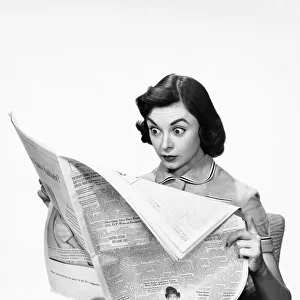Shocked woman reading newspaper
